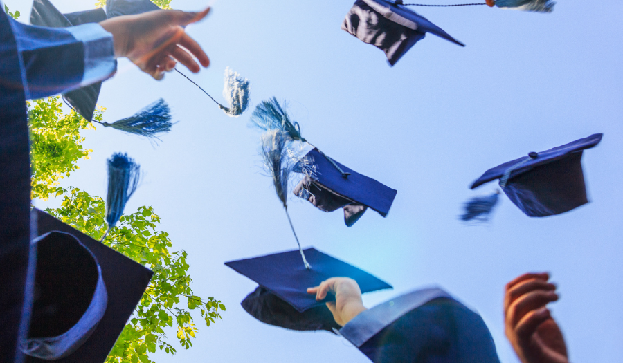 Blue graduation caps in the air